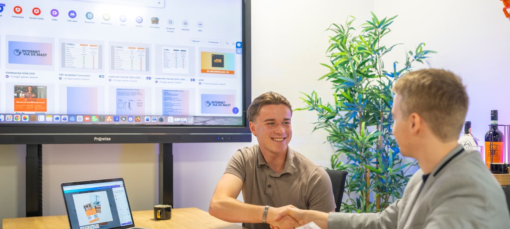 Een adviseur van ReviewRain schudt een ondernemer de hand aan een vergadertafel